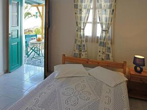 a bedroom with a bed and a window with a patio at Irene Rooms in Chora Folegandros
