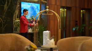 a man standing in a room with a wii controller at BAZ Hotel Airport Road in Baghdād