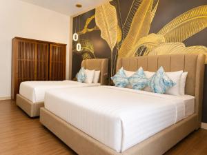 a bedroom with two beds and a painting on the wall at MAHAMAYA Gili Meno in Gili Meno +59 photos