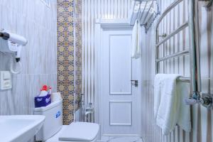 a bathroom with a toilet and a sink and a door at Merhaba Hotel, Fergana in Fergana +40 photos