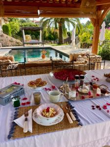 a table with food on it next to a swimming pool at B&B Villa Ganesh in Le Rouret