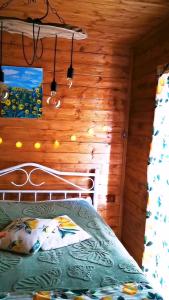 a bedroom with a bed in a log cabin at Kazbegi Mountain Cottage MTA-Shi in Kazbegi