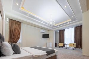a bedroom with a bed and a chandelier at Merhaba Hotel, Fergana in Fergana
