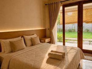 a bedroom with a large bed with a large window at Qwank Kuta Lombok in Kuta Lombok +38 photos