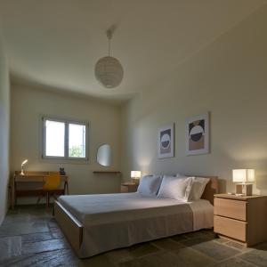 a bedroom with a bed and a desk and a window at Sea Breeze in Otziás
