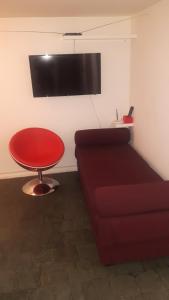 a living room with a red couch and a table at Double Kit 404 - 2 Quartos Perto UNB in Brasilia