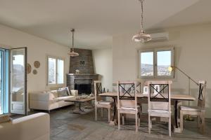 a living room with a table and a fireplace at Sea Breeze in Otziás