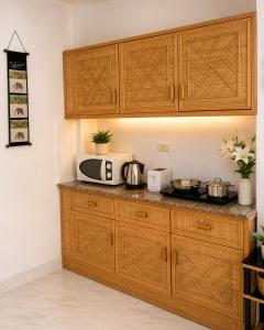 a kitchen with wooden cabinets and a microwave at View Talay 1B Holidays in Pattaya South