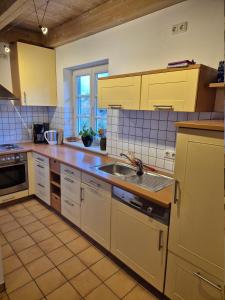 a kitchen with yellow cabinets and a sink at Ferienwohnung de Best inkl. Chiemgaukarte in Siegsdorf