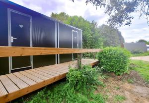 a building with a wooden bench in a yard at Camp Diekirch - Camping Pod in Gilsdorf