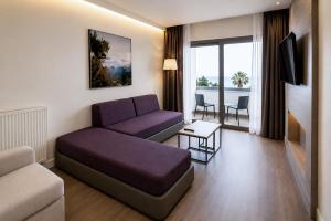a living room with a couch and a tv at Droushia Heights Hotel in Drousha
