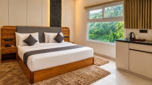 a bedroom with a bed and a large window at The JJ Corbett Bliss, Sitabani A River Access Wildlife Resort in Amgarhi +54 photos