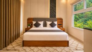 a bedroom with a bed and a large window at The JJ Corbett Bliss, Sitabani A River Access Wildlife Resort in Amgarhi