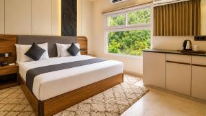 a bedroom with a bed and a large window at The JJ Corbett Bliss, Sitabani A River Access Wildlife Resort in Amgarhi