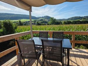 a table and chairs on a deck with a view at Camp Diekirch - Mobilehome Plus 6 pers in Gilsdorf