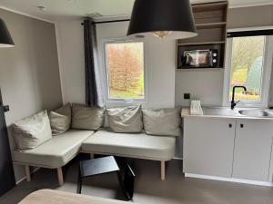 a living room with a couch and a kitchen at Camp Diekirch - Mobilehome Plus 6 pers in Gilsdorf