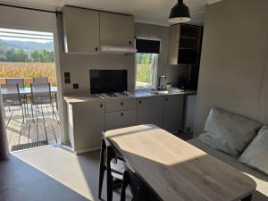 a kitchen and living room with a table and a couch at Camp Diekirch - Mobilehome Plus 4p in Gilsdorf