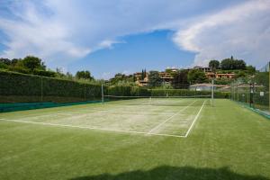 a tennis court with green grass on it at MGH Luxury- Romantic SPA & Relax in Poiano