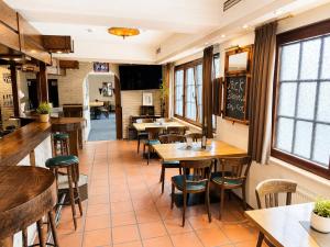 a restaurant with tables and chairs and a chalkboard at Hotel Panorama Nickenich in Nickenich