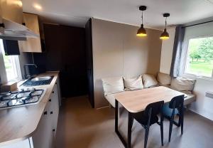 a small kitchen with a table and a couch at Camp Diekirch - Mobilehome Plus 4p in Gilsdorf +10 photos