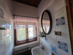 a bathroom with a sink and a mirror and a window at Penzión U Koníka in Liptovský Ján +27 photos
