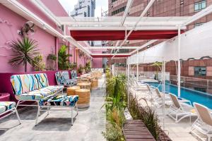 an outdoor patio with chairs and a pool at The Kuala Lumpur Journal Hotel in Kuala Lumpur