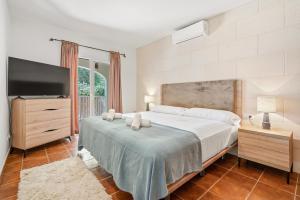 a bedroom with a large bed and a flat screen tv at SolParc 589 by 3VILLAS in Son Parc