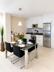 a kitchen and dining room with a table and chairs at Les Cotolles Centro in Cangas de Onís