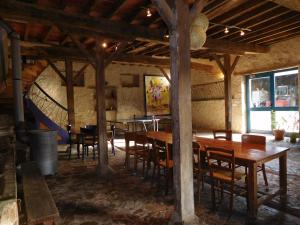 a dining room with wooden tables and chairs at Chambres d'hôtes Ferme de Sardonnet in Allouis