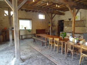 a dining room with a long wooden table and chairs at Chambres d'hôtes Ferme de Sardonnet in Allouis +18 photos