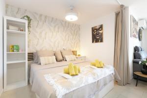 a bedroom with a large white bed with yellow pillows at Infinity Summer in San Miguel de Abona +19 photos