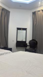 a bedroom with a bed and a mirror and a chair at شقة فاخرة بغرفتين نوم وصالة ومجلس in Abha +3 photos