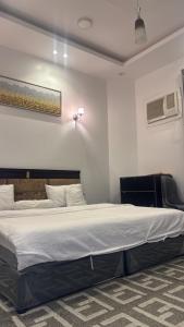 a bedroom with a large bed in a room at شقة فاخرة بغرفتين نوم وصالة ومجلس in Abha