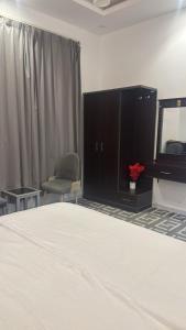 a bedroom with a bed and a dresser and a mirror at شقة فاخرة بغرفتين نوم وصالة ومجلس in Abha
