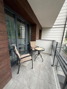 a patio with a table and chairs on a balcony at ''Панорама Карпат'' Апартаменти в чудовому місті Яремче in Yaremche