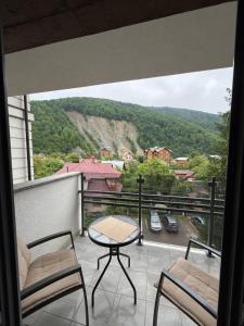 a balcony with a table and chairs and a view at ''Панорама Карпат'' Апартаменти в чудовому місті Яремче in Yaremche +53 photos