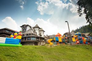 a playground in front of a large house at Termag Hotel Jahorina in Jahorina