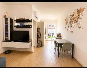 a living room with a table and a dining room at Incanto patio house in Sestu