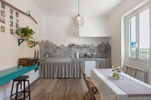 a kitchen with a table and a counter top at Il Leone Bianco Affittacamere in Albenga