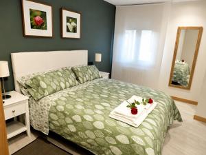 a bedroom with a bed with two towels and a mirror at Les Cotolles Centro in Cangas de Onís