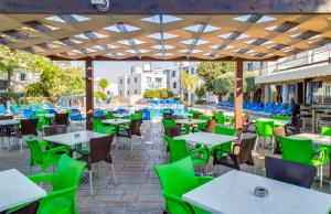 an outdoor patio with tables and chairs and blue chairs at Green Bungalows Hotel Apartments in Ayia Napa
