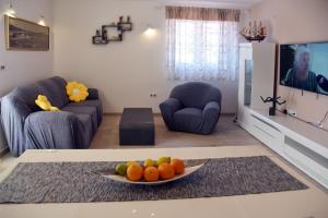 a living room with a plate of fruit on a table at Dalmatino 3 Rukavac Vis in Rukavac