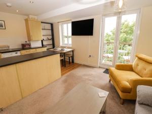 a kitchen and living room with a couch and a table at Twyni Bach in Burry Port