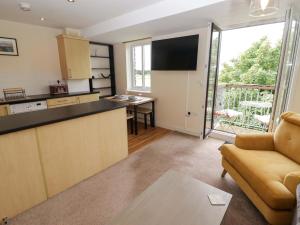 a kitchen and living room with a couch and a table at Twyni Bach in Burry Port