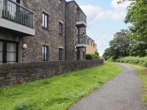an empty road next to a brick building at Twyni Bach in Burry Port
