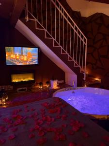 a large bathroom with a tub with a tv and a staircase at Ama Collection Esclusive Spa in Bologna