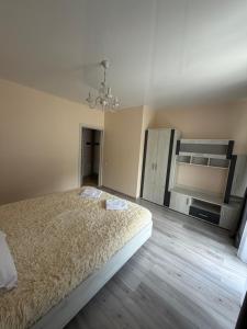 a bedroom with a large bed and a chandelier at ''Панорама Карпат'' Апартаменти в чудовому місті Яремче in Yaremche