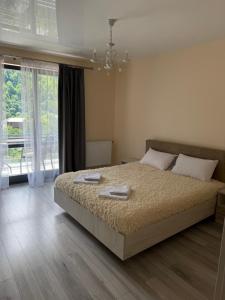a bedroom with a bed and a large window at ''Панорама Карпат'' Апартаменти в чудовому місті Яремче in Yaremche