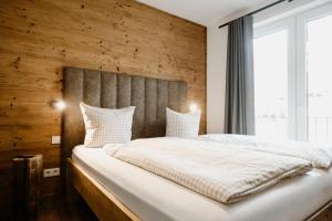 a bedroom with a large bed with a wooden wall at FourElements Grand Chalet in Blankenburg