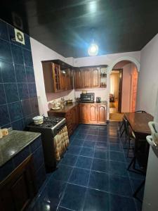 a kitchen with wooden cabinets and a blue tile floor at there is no a name in Itʼkhvisi